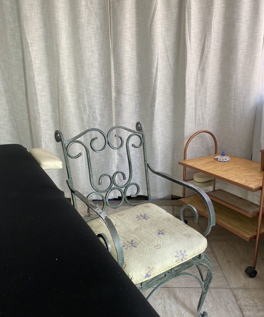 Silla verde con cama de masajes al lado