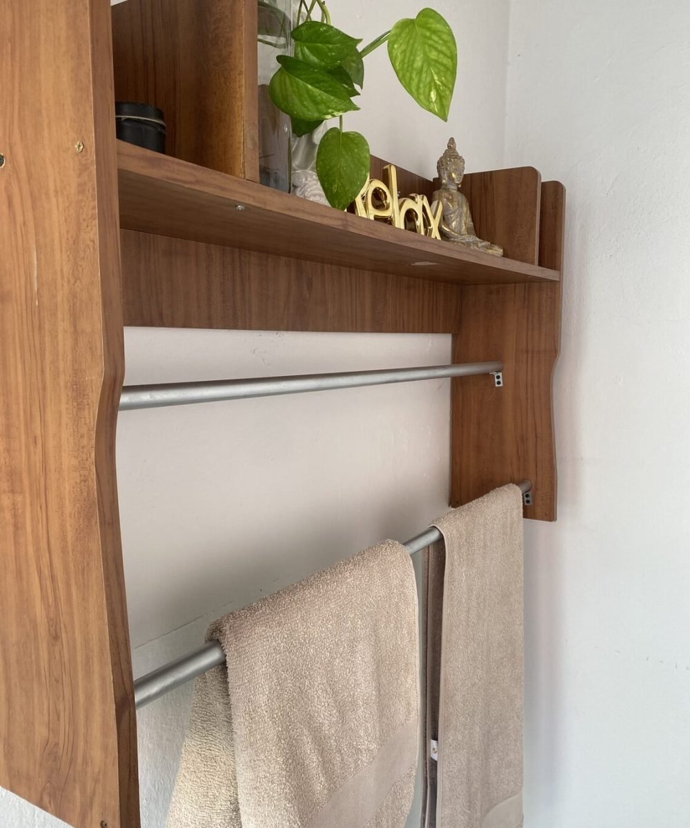 toallas en un colgador cafe con plantas y decoracion de buda arriba del colgador